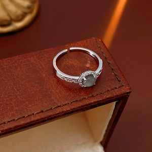 Detailed macro view of silver flower ring with grey gemstone on vintage leather box