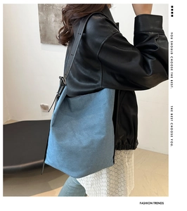 Seitenansicht der großen Denim-Einkaufstasche mit verstellbarem Ledergurt am Model