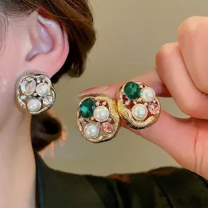 Vintage irregular gold-framed earrings with faux pearls and sparkling gems shown on model