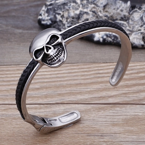 Makroansicht der geflochtenen Lederstruktur und Totenkopfdetails aus Edelstahl am Armband