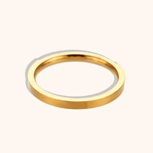 Dettaglio dell'anello a fascia larga placcato oro 18 carati su uno sfondo beige neutro