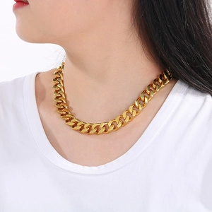 Close-up of 13mm 18K gold-plated Cuban link chain worn by a model on a white background
