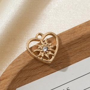 Macro detail of a hollow gold heart pendant with a star-shaped center and sparkling zircon