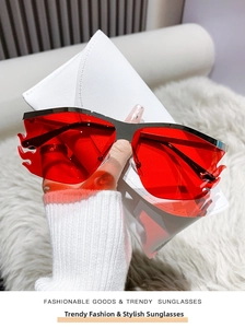 Detailed view of red flame-shaped rimless sunglasses with a white textured leather case