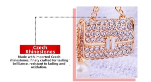Close-up of golden bag charm with Czech rhinestones and a large white pearl drop