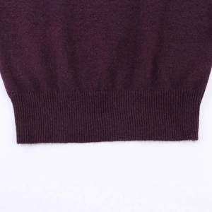 Détail de l'ourlet côtelé du pull en maille violet foncé en laine douce mélangée