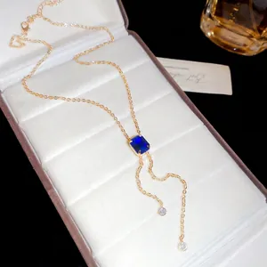 Elegant gold tassel necklace with a rectangular deep blue gemstone on velvet lining