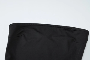 Detailaufnahme der präzisen Nähte am Taillenbund eines schwarzen trägerlosen Kleids