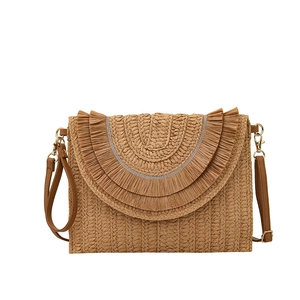 Close-up of woven raffia envelope clutch with layered fringe detail and leather strap