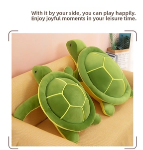 Close-up of green turtle plush toys in two sizes on a soft yellow sofa