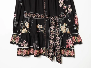 Détails de la ceinture à nouer et de l'imprimé floral sur une robe longue vintage