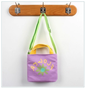 Detail of purple canvas tote bag for kids with yellow handles and adjustable green strap