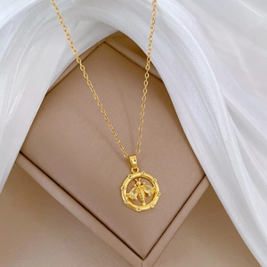 Exquisite gold bee pendant necklace with zircon halo on white silk and beige box background