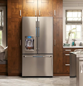 Close-up of stainless steel French door refrigerator with water dispenser in wood cabinet