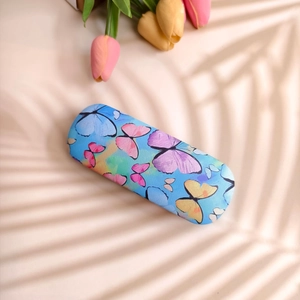 Blue oil painting glasses case with butterfly pattern and linen texture on a beige surface