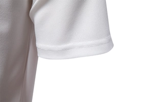 Close-up of white piqué knit polo shirt cuff showing breathable mesh texture and stitching