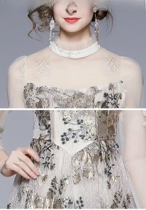 Detaillierte Bestickung auf einem französischen Langarm-Netzkleid in Champagner
