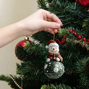 Christmas snowman car pendant with green bell and red scarf hanging on a festive tree