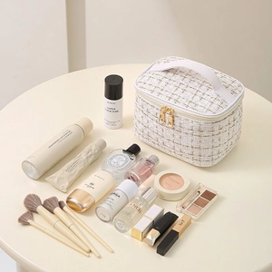 Large tweed cosmetic bag in white and gold weave with top handle for travel organization