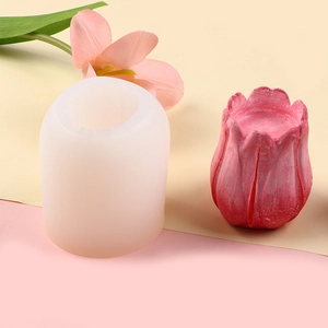 Macro detail of tulip-shaped candle with translucent silicone flower mold on pink background