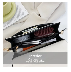 Detail view of the spacious multi-layered interior of the black and white crossbody bag
