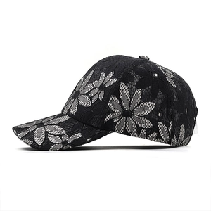 Close-up of intricate white daisy lace patterns on a breathable black baseball cap