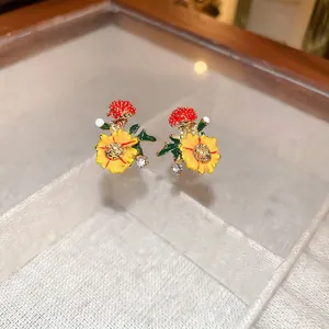 Floral stud earrings with orange oil-drop sunflowers and tiny diamonds on gold base