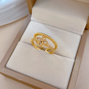 Close-up of golden double-layer open ring with sparkling clover zircon in a jewelry box