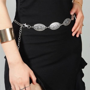 Close-up of silver metal chain belt with embossed turquoise oval plates on a model