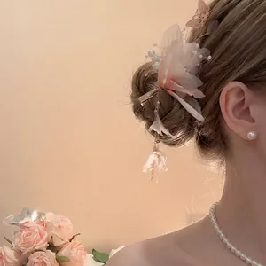 Elegante fermaglio per capelli a fiore con perle e nappe dorate su modella