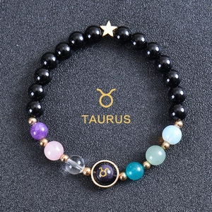 Detailed view of beaded zodiac bracelet with black obsidian, colorful gems, and Taurus charm