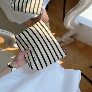 Macro detail of black and white striped travel cosmetic bag with woven fabric texture