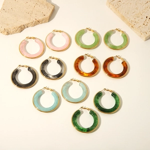 Fashionable resin thick hoop earrings with gold trim edge on minimalist white background