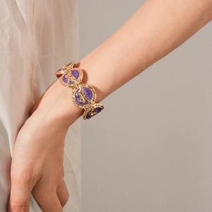 Detail of vintage purple enamel butterfly bracelet with gold filigree on a model wrist