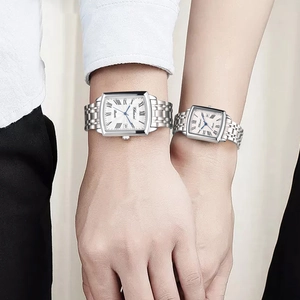 Close-up of couple watches with square roman dial and metal strap on wrists