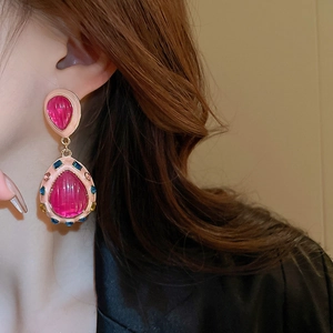 Detail of vintage teardrop earrings with pink crystals and colorful rhinestones on model