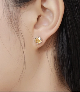 Close-up of a model wearing a classic round-cut champagne zircon stud earring in silver