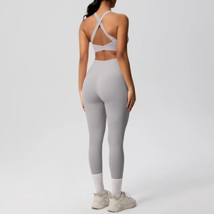 Dettaglio del set yoga grigio chiaro con reggiseno sportivo incrociato e leggings slim