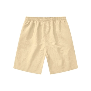 Detail of light beige tactical sports shorts showing crinkled fabric texture and elastic waist