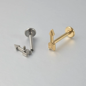 Détail de piercings labret en titane avec filetage interne et embouts en flèche