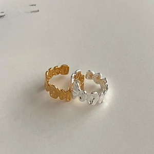 Detail showing S925 hallmark on irregular wavy gold and silver minimalist rings
