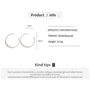 Detail view of 6cm large C-shaped hoop earrings with graduated pearls and gold accents
