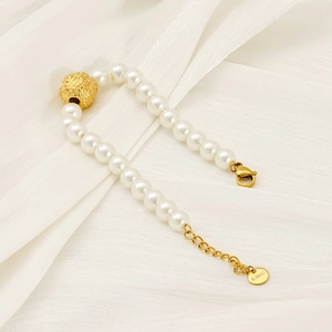 Détail du bracelet en perles avec bille dorée mate et chaîne d'extension en acier