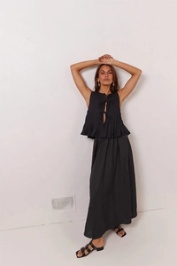 Detail of black sleeveless tie-up top and pleated maxi skirt in cotton linen fabric