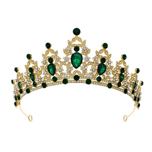 Detailed macro view of vintage gold crown with emerald crystals and sparkling rhinestones