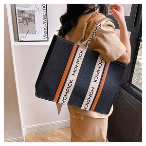 Detail shot of felt tote bag with contrast leather trim and MOMPICK branded ribbons