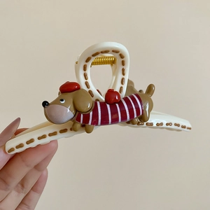 Detail of dachshund hair claw clip with red beret and striped sweater design
