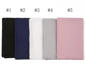 Detail of five solid color mercerized cotton scarves neatly folded in a row