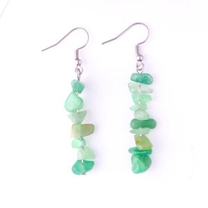 Macro shot of handmade natural green raw gemstone dangle earrings with silver hooks
