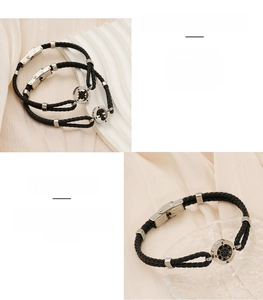 Detailed macro view of black braided leather bracelet with stainless steel compass charm